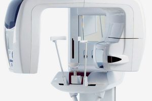 Picture of white and blue panoramic x ray machine with arm that rotates around patient's head