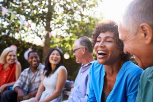 group of friends sitting outside talking and laughing