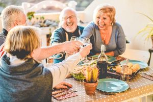 group of older aged friends toasting their drinks