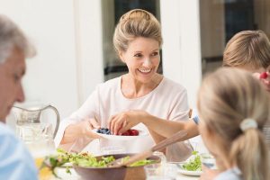 grandmother sitting at a dinner table with family