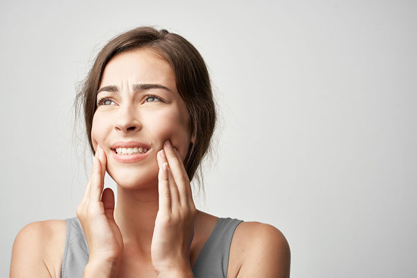 woman feeling pain on both side of her cheeks